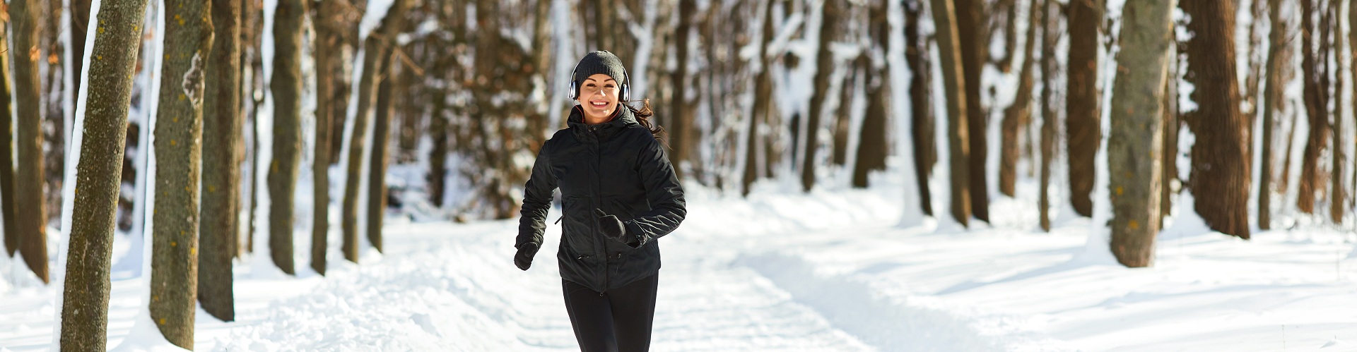 Girl jogging in the snow on the nature in winter